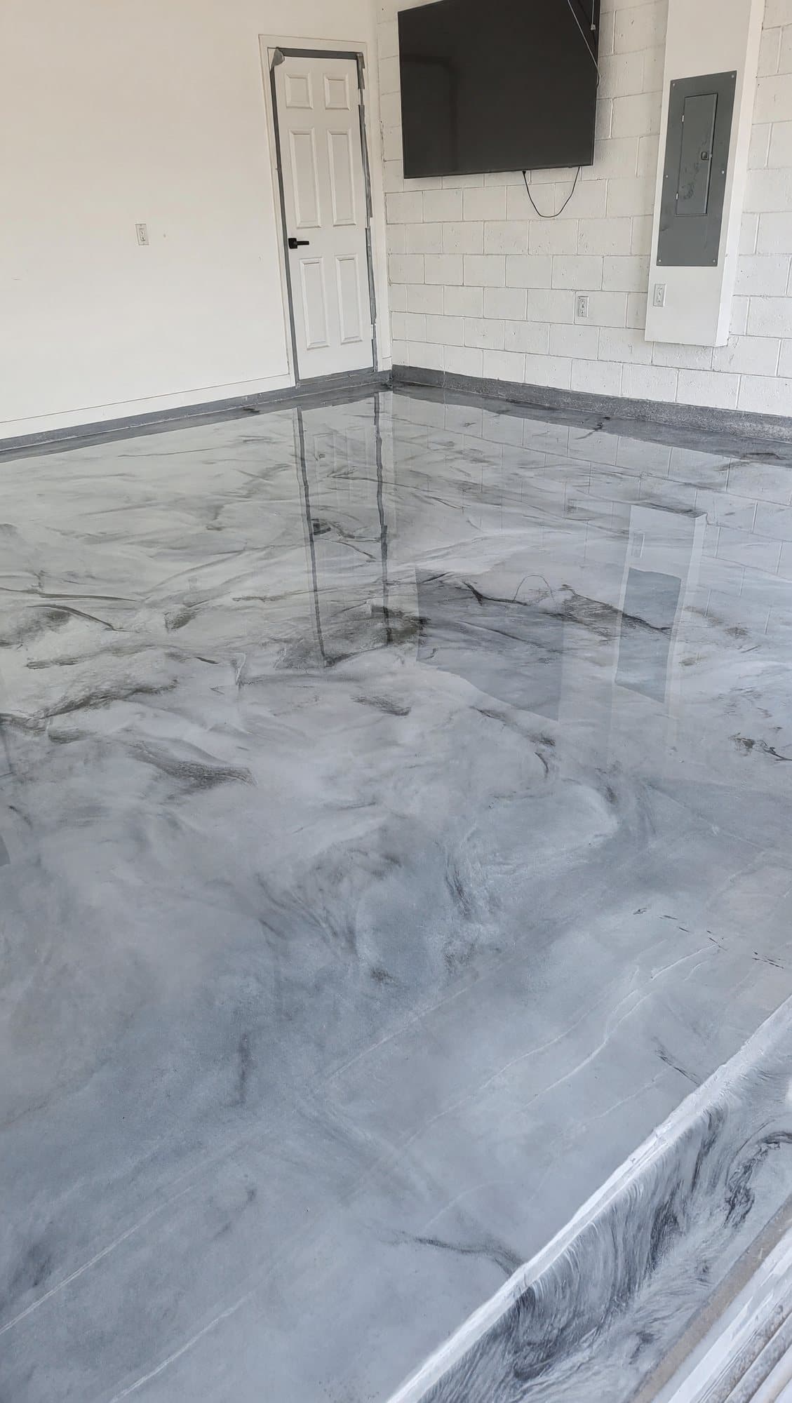 High-gloss gray and white metallic epoxy floor in a residential garage